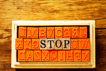 木目の上に置いたハンコ　STOP の文字と木目の背景