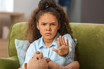 African-American girl showing STOP gesture at home
