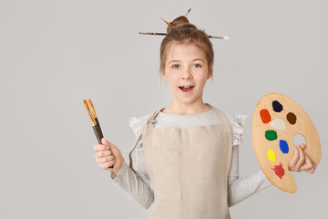 Cute little artist on light background