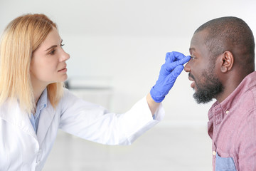 African-American man meeting with plastic surgeon in clinic