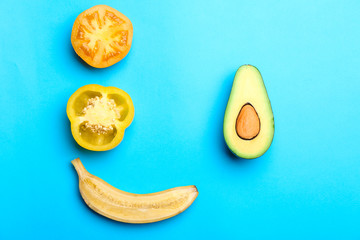 Fresh avocado, banana, tomato and pepper on color background