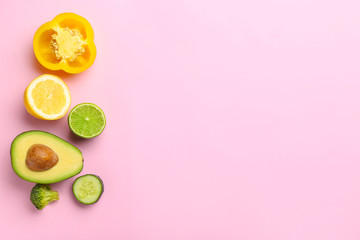Fresh avocado, fruits and vegetables on color background
