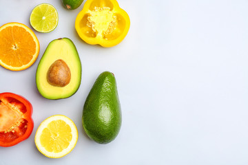Fresh avocado, fruit and vegetables on light background