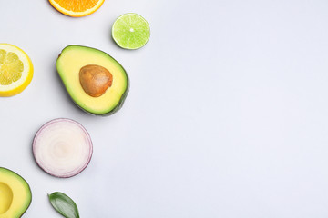 Fresh avocado, fruit and vegetables on light background