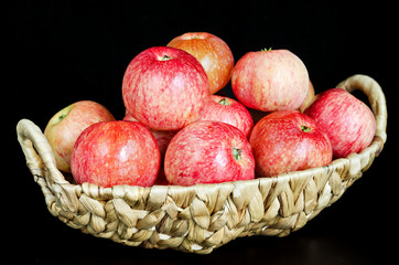 Ripe red apples in a wicker basket. Black background