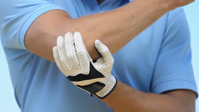 Man in golf uniform developing elbow feeling pain and cramp, joint problems