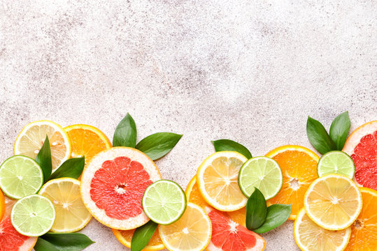 Different citrus fruits on grey background