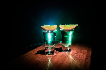 Club drink concept. Tasty alcohol drink cocktail tequila with lime and salt on vibrant dark...