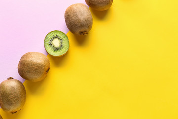 Whole kiwifruits and one half on color background. Concept of uniqueness