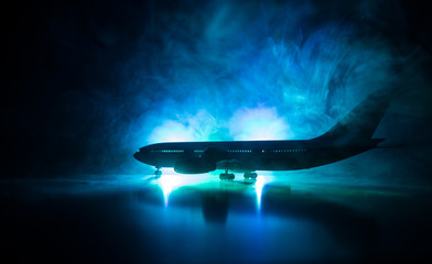 Artwork decoration. White passenger plane ready to taking off from airport runway. Silhouette of Aircraft during night time.