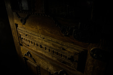 Close up view of old antique wooden door inside dark room. Selective focus
