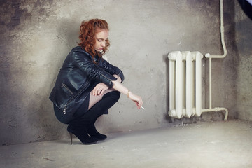 Girl addict in a leather jacket with a dose in a syringe prostitute