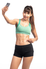 Fototapeta na wymiar Fitness woman using mobile phone. Asia girl, doing selfie, pointing at her abs.