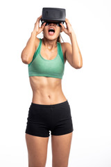 Fitness woman wearing VR headset isolated in white background. Asian girl, scared look.