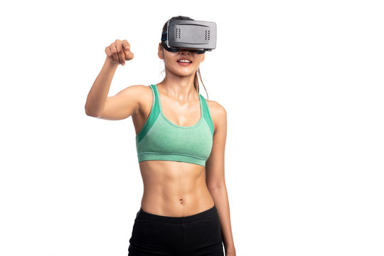 Fitness woman wearing VR headset isolated in white background. Asian girl, point finger at screen, half bopy shot.
