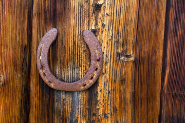old rusty horseshoe on a wooden wall surface