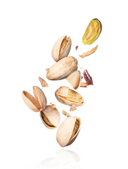 Pistachios crushed into pieces in the air close-up on white background