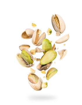 Pistachios crushed into many pieces on a white background