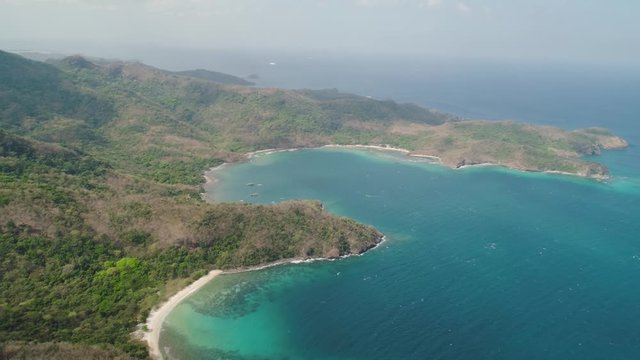 Aerial view coastline with tropical beach, island Limbones, lagoons and coral reefs. Neela cove, Philippines, Luzon. Coast ocean with turquoise water. Tropical landscape in Asia.