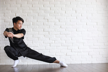 Asian young novice on a white brick wall