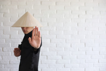 Asian young novice on a white brick wall