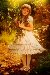 Adorable little girl in blooming apple tree