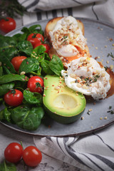 Toasts with avocado and poached egg, tomatoes and spinach, On a light gray background, Fresh morning breakfast