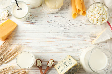 Fototapeta na wymiar Flat lay. Different dairy products on white wooden background, copy space