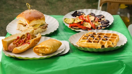 Burger, hot-dog and grill vegetables at outdoor festival. Outdoor cooking, gastronomy and street food concept