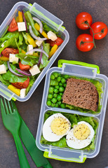 Lunch box with tomatoes, lettuce and sandwich. Top view.