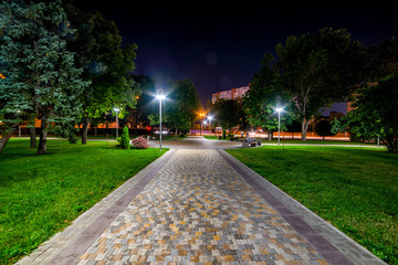 Beautiful city park walkway with lamps at night - Powered by Adobe