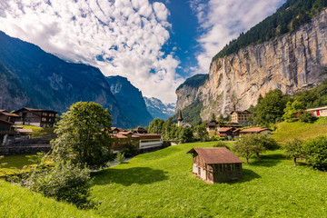Famous view of Lauterbrunnen town in Swiss Alps valley with gorgeous Staubbach waterfalls in the...