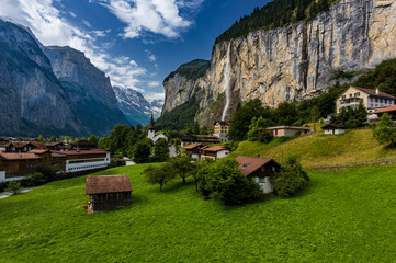 Famous view of Lauterbrunnen town in Swiss Alps valley with gorgeous Staubbach waterfalls in the...