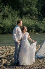 Beautiful bride and groom. Just merried. wedding couple.Close up. Happy bride and groom on their wedding hugging. bride and groom in mountains, beautiful nature, landscape, fog, stream