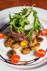 Grilled steak with fresh tomatoes and garlics.