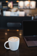 cup of coffee latte on wooden table in a cafe