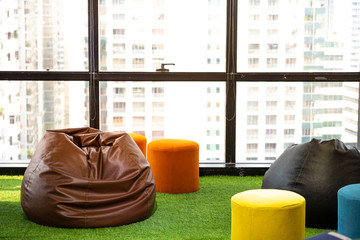 leather beanbags on fake green grass.. work place view