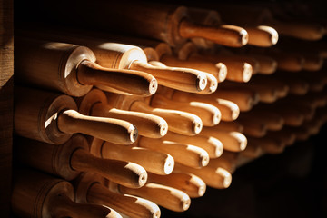 Pile of traditional wooden rolling pins on the counter of a souvenir store under moody natural light