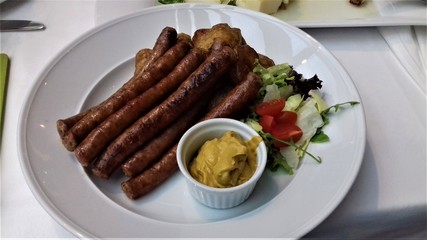 meat sausages with vegetables and sauce on a plate