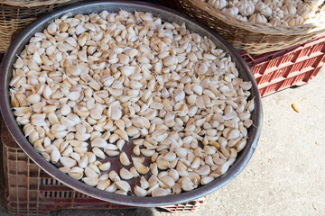 Gloves of garlic for sale at weekly farmers market in Yenifoca in the Izmir province in Turkey. Several garlic gloves presented on large metal plate at market stall. 