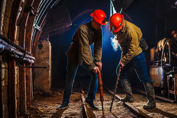 Two miners in the mine. Hard work in a coal mine. Copy space. Tired workers in a coal mine