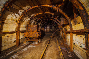 Fototapeta na wymiar Underground mining tunnel with rails. Copy space. Work in an underground coal mine