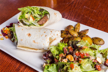 delicious beef kabab with fresh salad and grilled garlic.