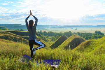 Girl in the nature doing yoga exercise for fitness.