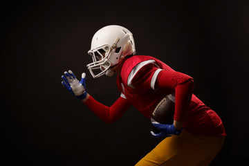 Photo of side of running female American soccer player in studio