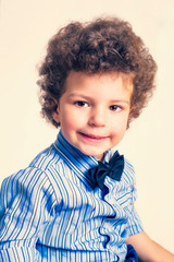 A kid portrait with curly hair on studio