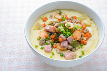 Steamed egg custard cuisine in a white bowl with minced pork, sausage and bacon.  Or Only with egg, water, salt and some sesame oil, you can make this super smooth custard at home.