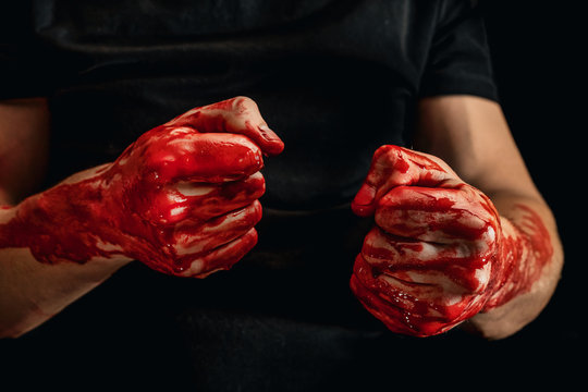 Male hands showing various gestures in the blood on a black background. broken fists in the blood