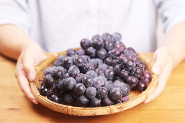 女性とテーブルの上のぶどう