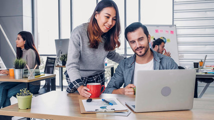 two of creative designer casual meeting with laptop at modern office in morning at desk.casual workplace lifestyle.